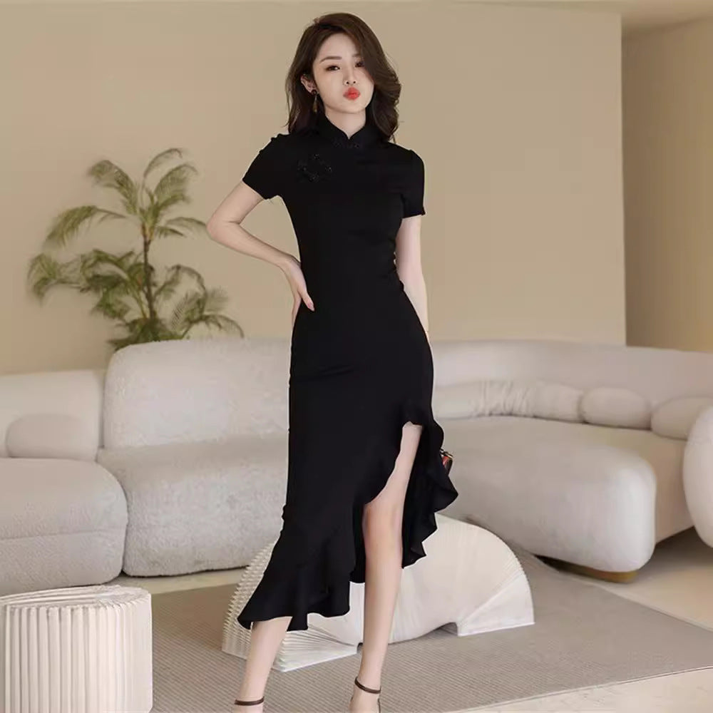 Woman in a black dress standing in a modern living room.