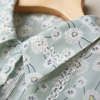 Light blue fabric with floral pattern and lace trim on a wooden surface