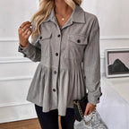 Woman wearing a gray corduroy jacket in an indoor setting.