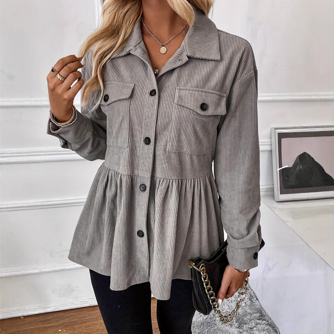 Woman wearing a gray corduroy jacket in an indoor setting.