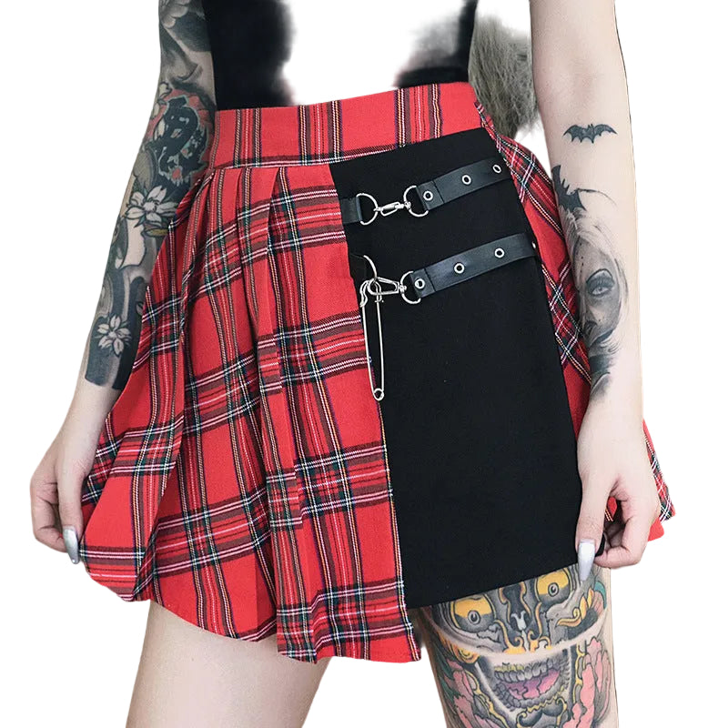 Person wearing a red plaid skirt with a black bag over it, standing against a natural background.