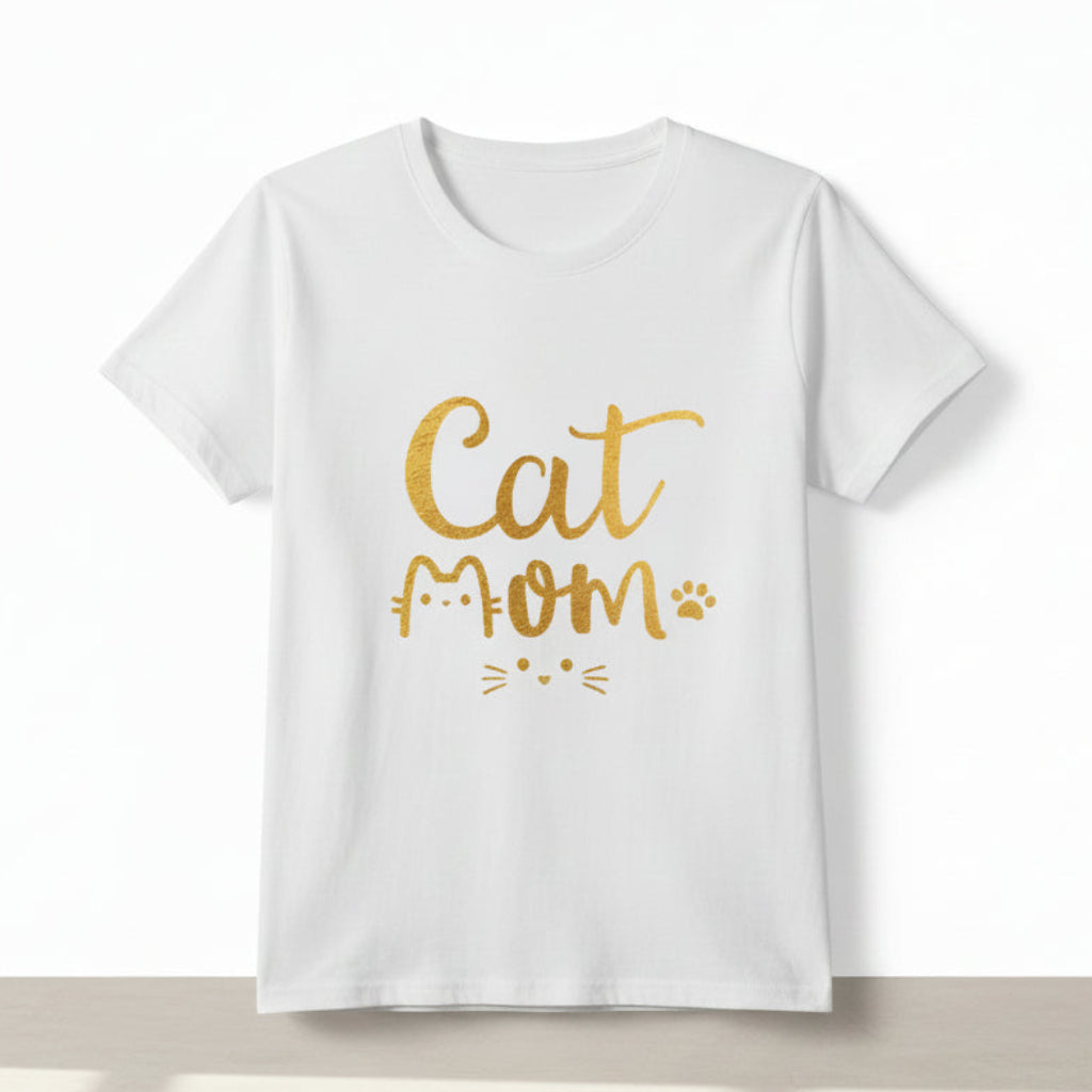 Person wearing a white t-shirt with 'Cat Mom' in gold text on a plain background