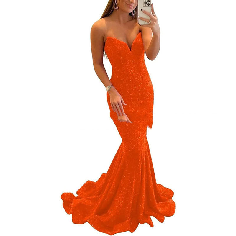 Orange evening gown worn by a model on a white background