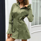 Woman wearing a green shirt dress against a neutral background